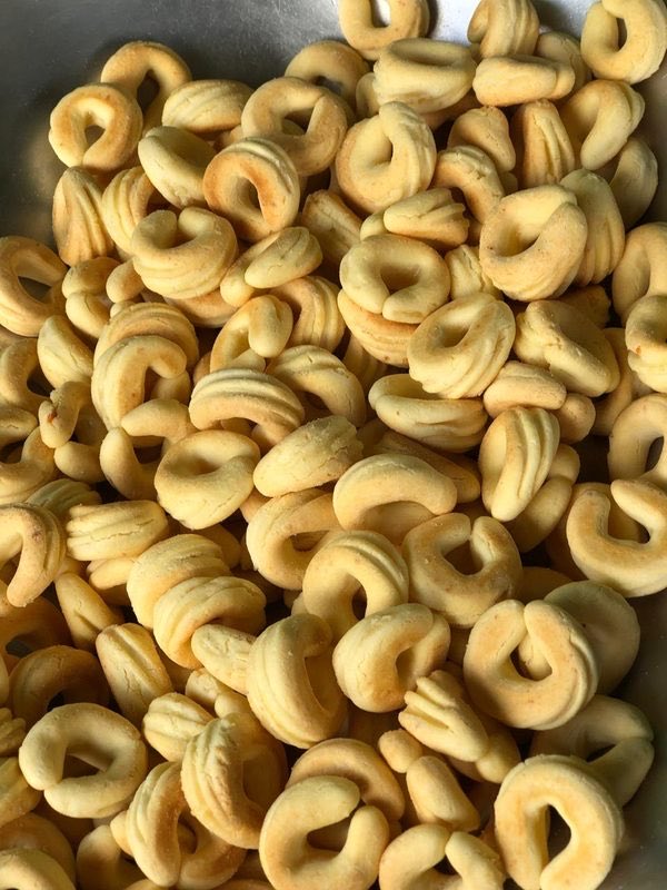 Biscoitos de queijo tradicionais em formato de ferradura, dourados, numa assadeira