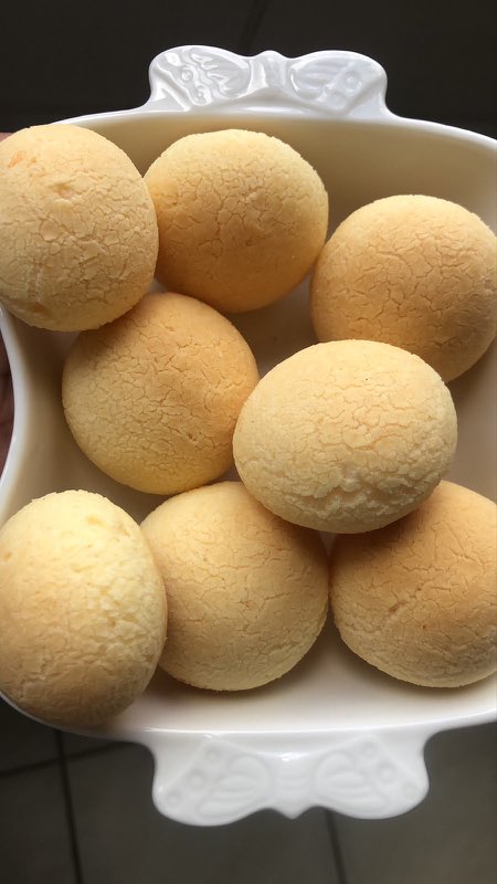 Pães de queijo tradicionais dourados numa travessa branca